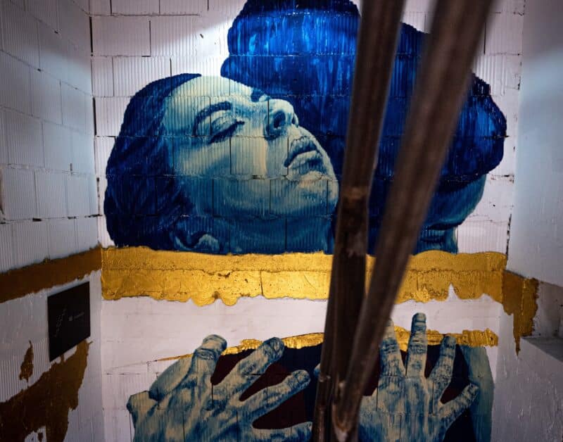 Painting Of A Woman's Face On A Stairwell Wall